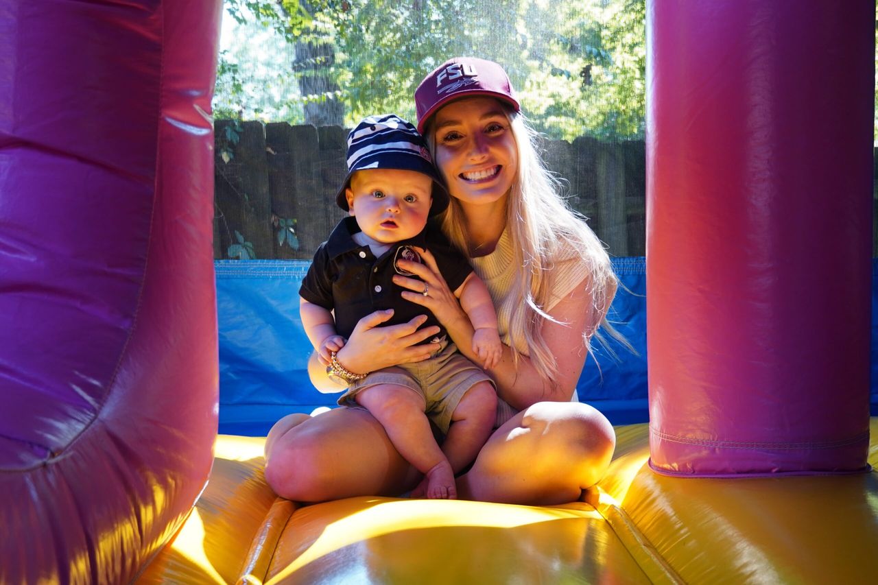 Molly holds Wyatt in the bounce house.