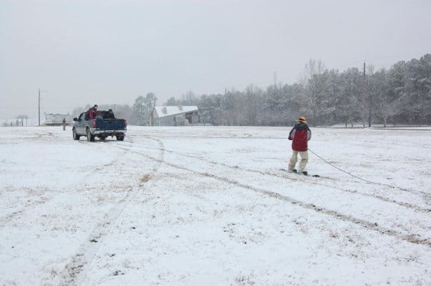 Andrew tries snowboarding while being pulled by a truck.