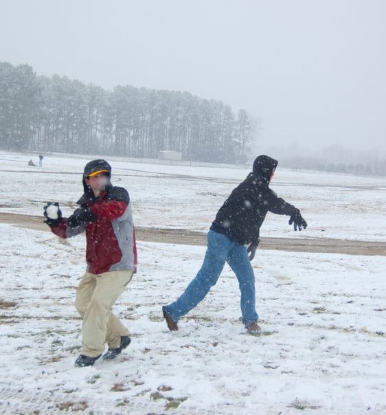 Andrew winds up to throw a snowball.