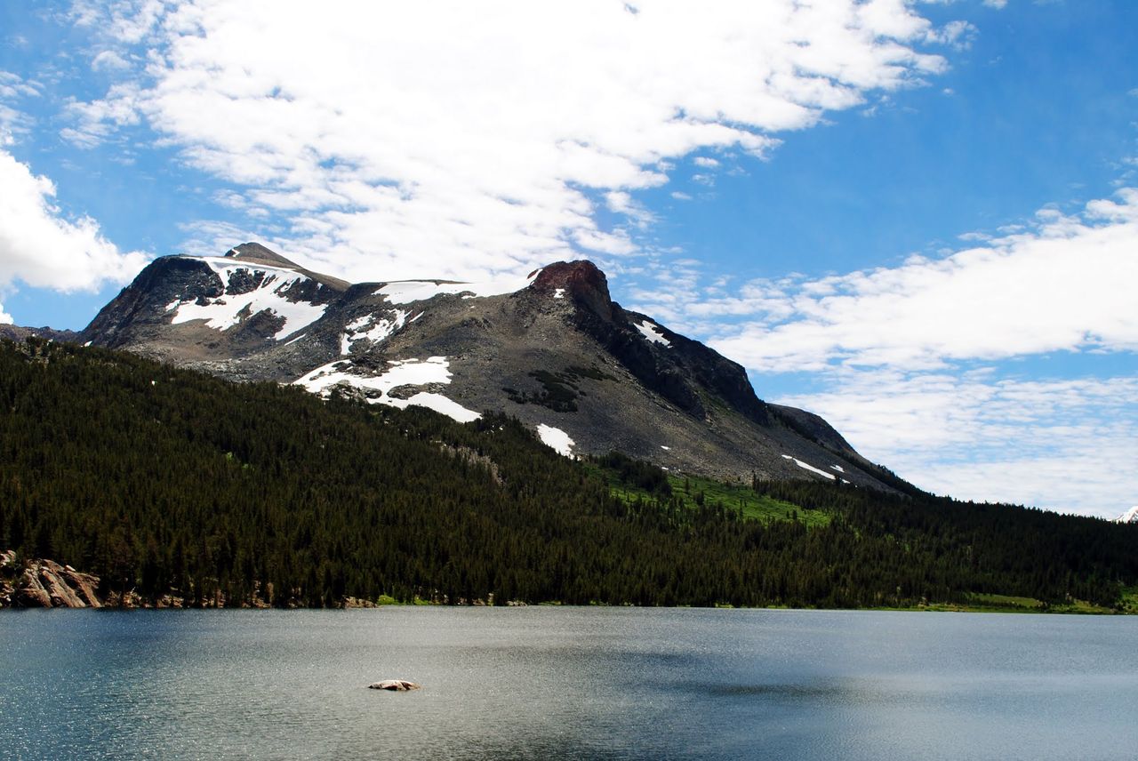 Snow-capped mountains behind a lake.