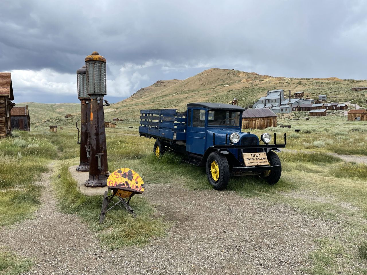An old truck next to a gas pump.