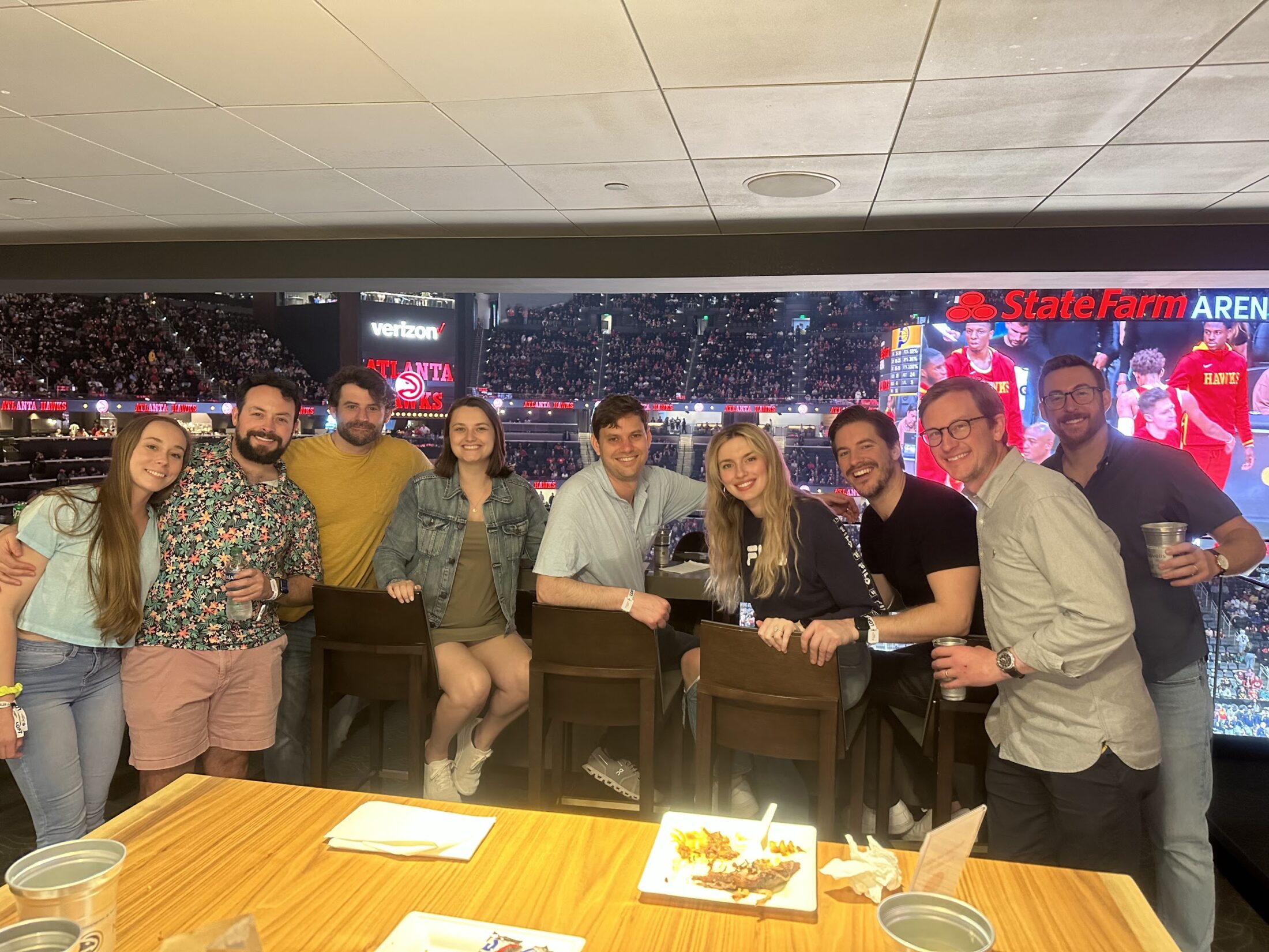 Friends posing for a picture at a Hawks game.